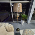 Stojací lampa ve zlatém provedení s elegantním stínidlem